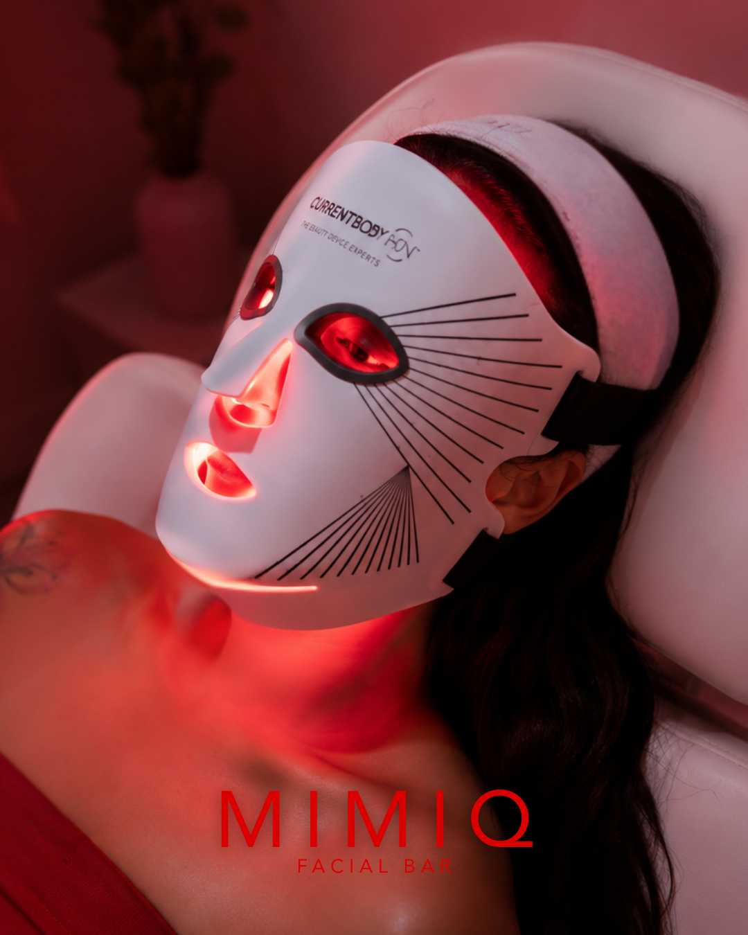 Client wearing a CURRENTBODY red LED light therapy mask during a MIMIQ facial in Bangkok